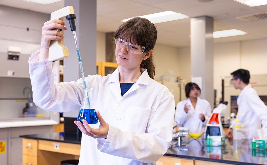 Madeleine in a lab conducting an experiment with classmates